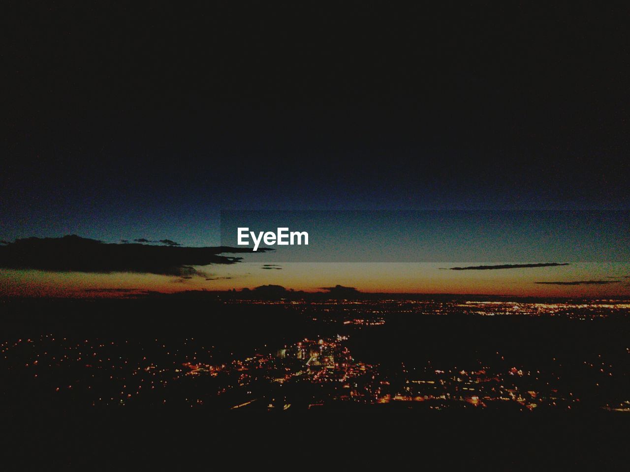 VIEW OF ILLUMINATED CITYSCAPE AT NIGHT