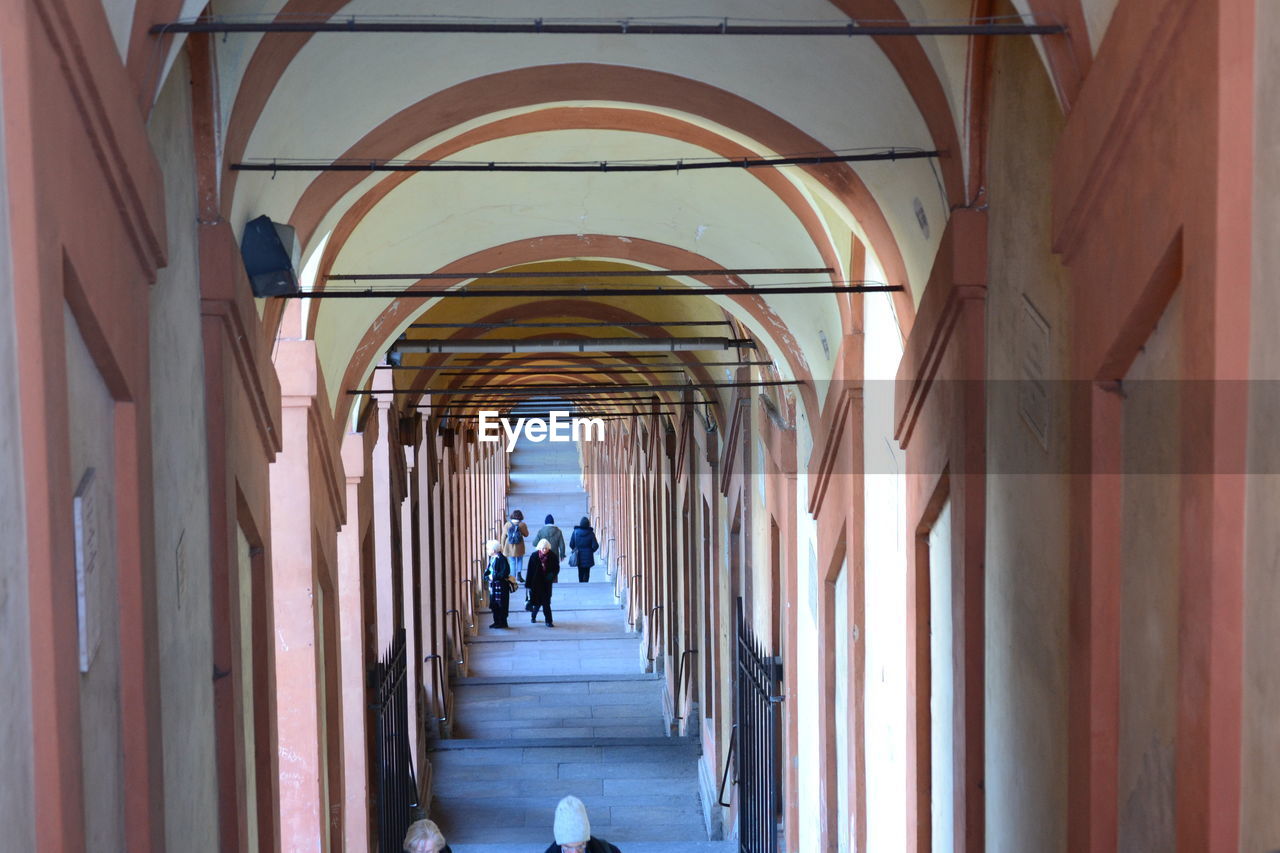 Rear view of people walking in corridor of building