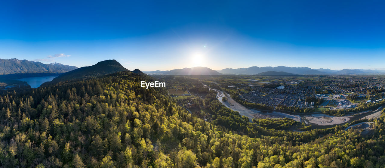 environment, landscape, mountain, scenics - nature, sky, land, mountain range, beauty in nature, nature, tree, plant, forest, wilderness, blue, travel, travel destinations, sun, tranquility, no people, panoramic, pine tree, pinaceae, ridge, sunlight, coniferous tree, outdoors, tranquil scene, sunset, cloud, valley, rural scene, non-urban scene, tourism, mountain peak, architecture, summer, plateau, twilight, pine woodland, woodland, sunbeam, field, environmental conservation, idyllic, sunny, social issues, clear sky, high angle view, activity, building, dusk, day, autumn