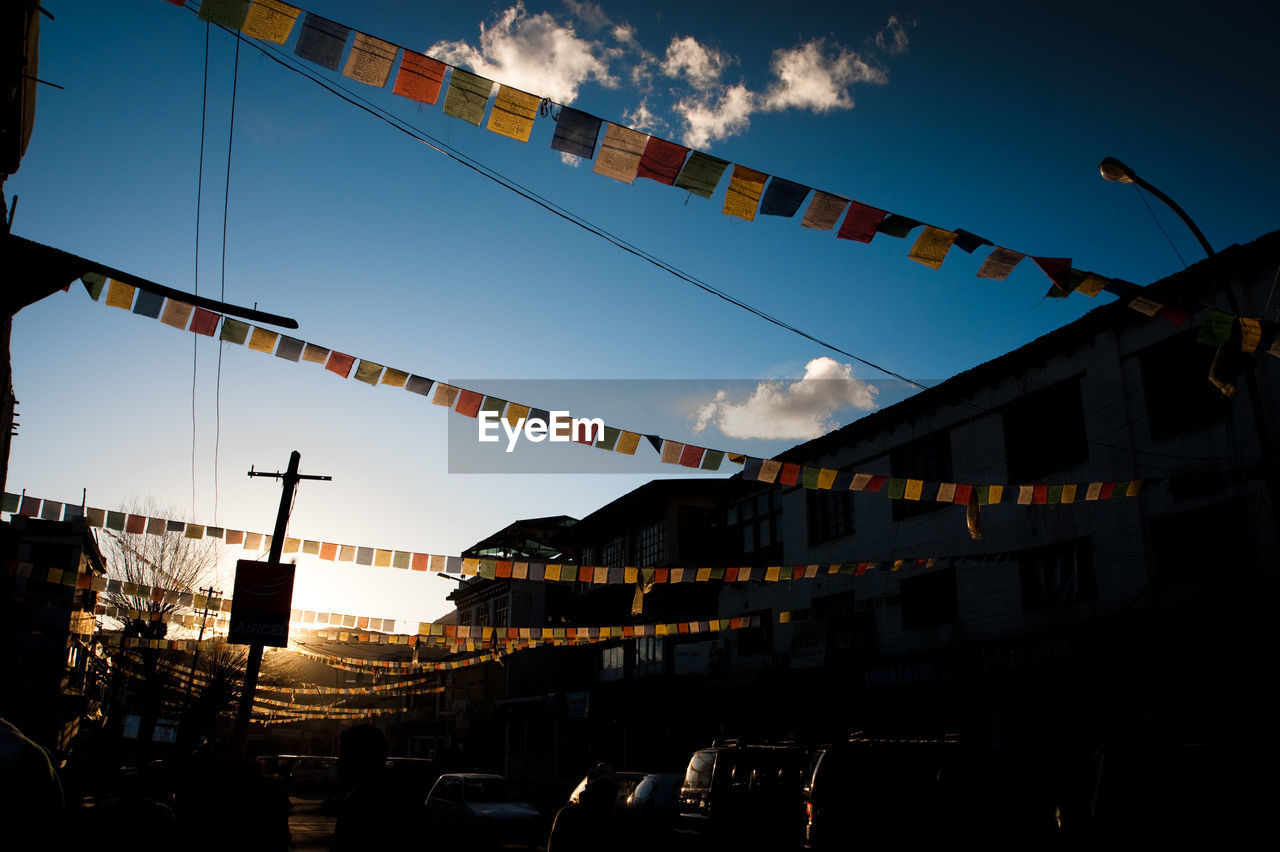 Low angle view of flags hanging against sky