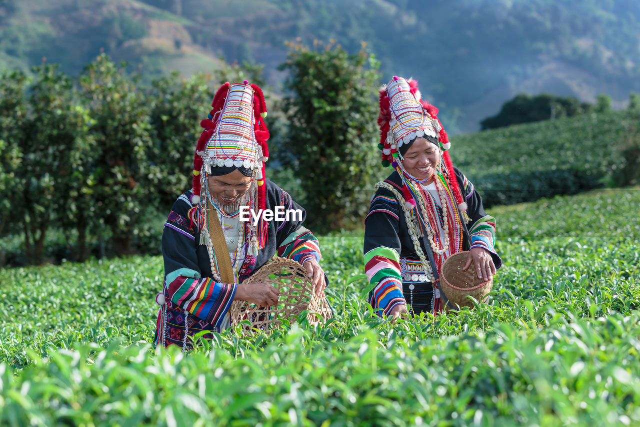 TWO PEOPLE SITTING ON GRASS