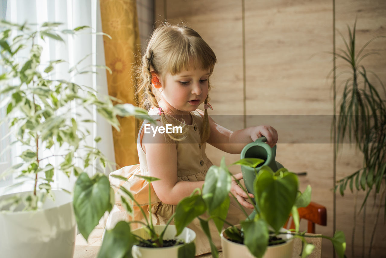 Girl watering plants at home