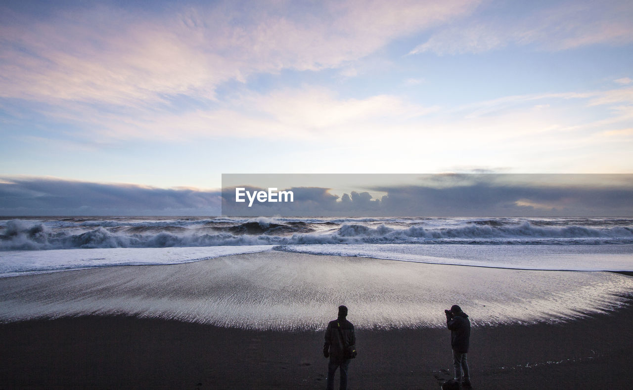 PEOPLE AT BEACH AGAINST SKY