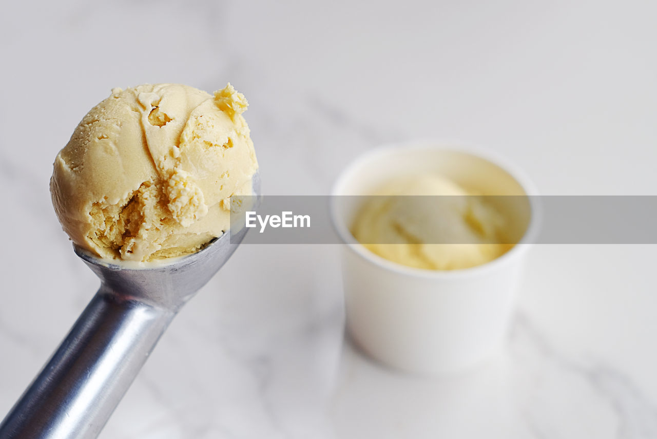 Close-up of ice cream on scoop over table