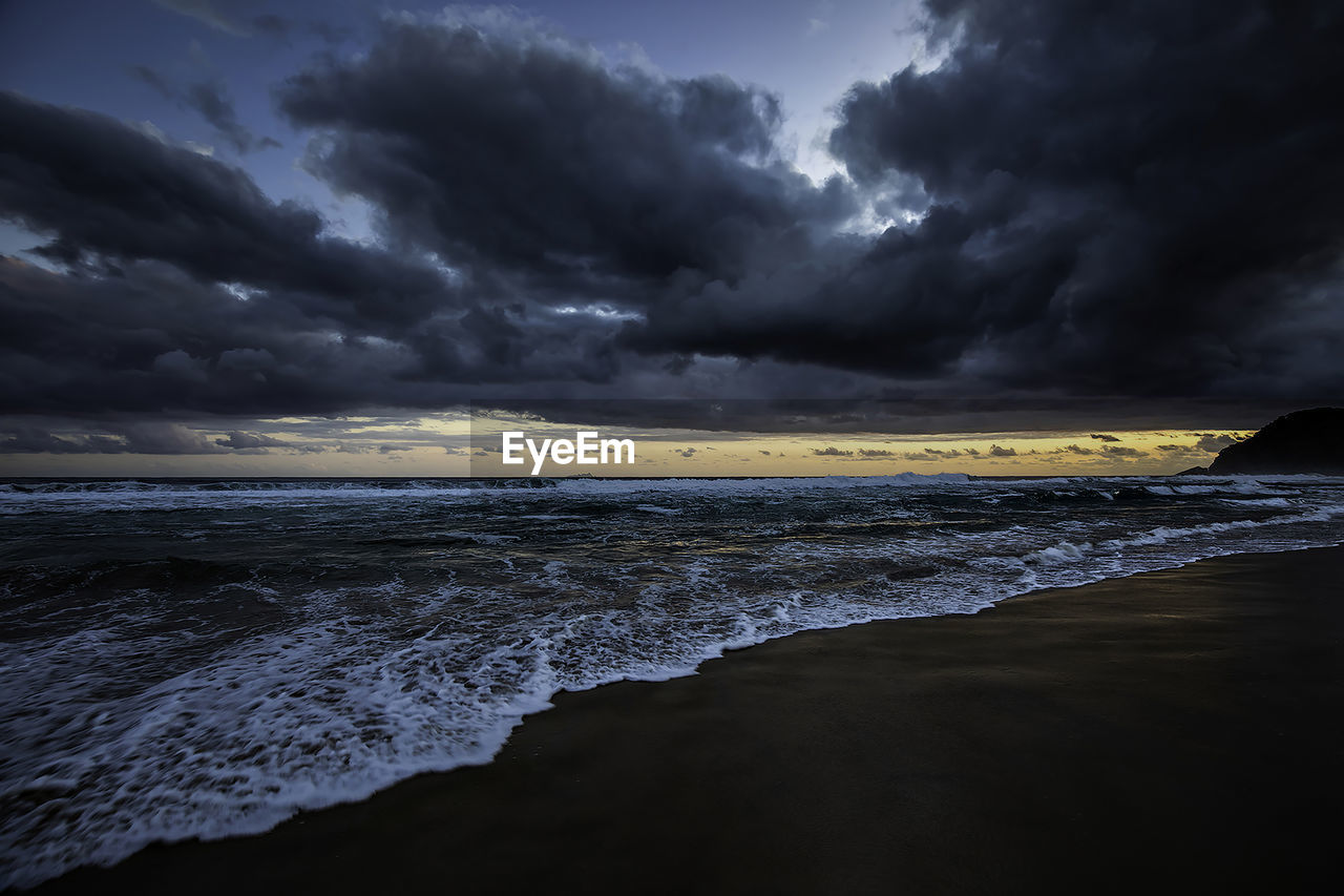 Sunset at the beach with heavy clouds