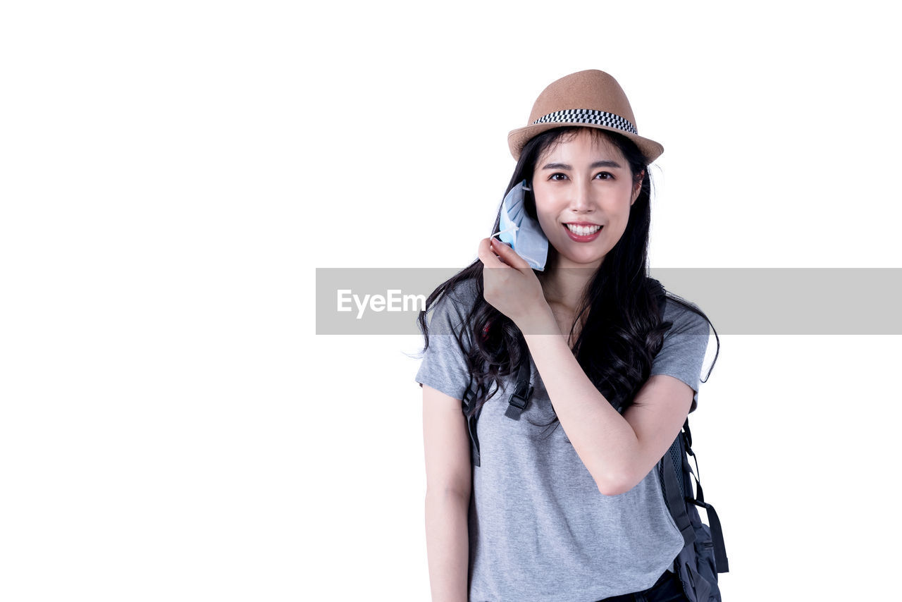 PORTRAIT OF BEAUTIFUL YOUNG WOMAN AGAINST WHITE BACKGROUND