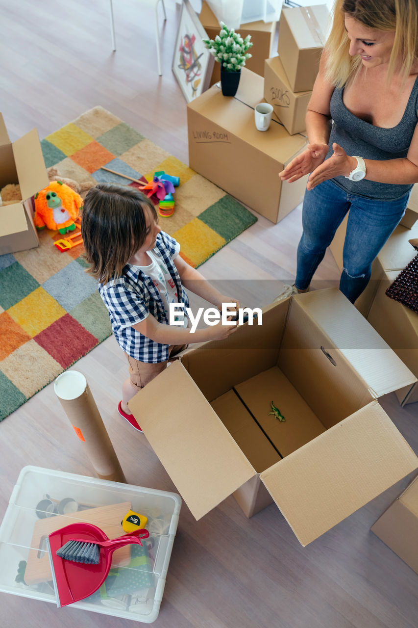 High angle view of mother with son unpacking boxes at home