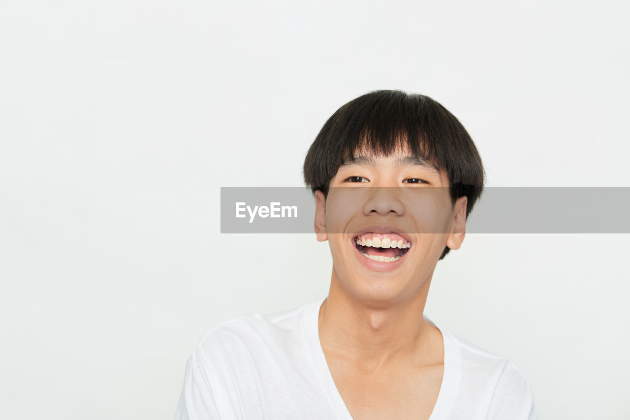 PORTRAIT OF YOUNG MAN AGAINST WHITE BACKGROUND