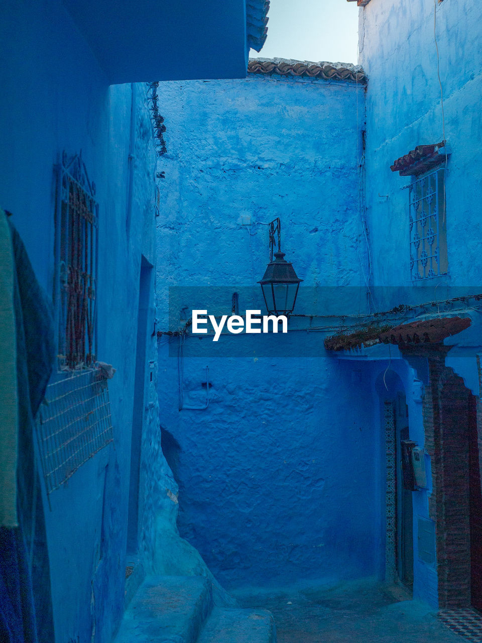 A little nook in the blue city of chefchaouen with a lantern and a hidden doorway