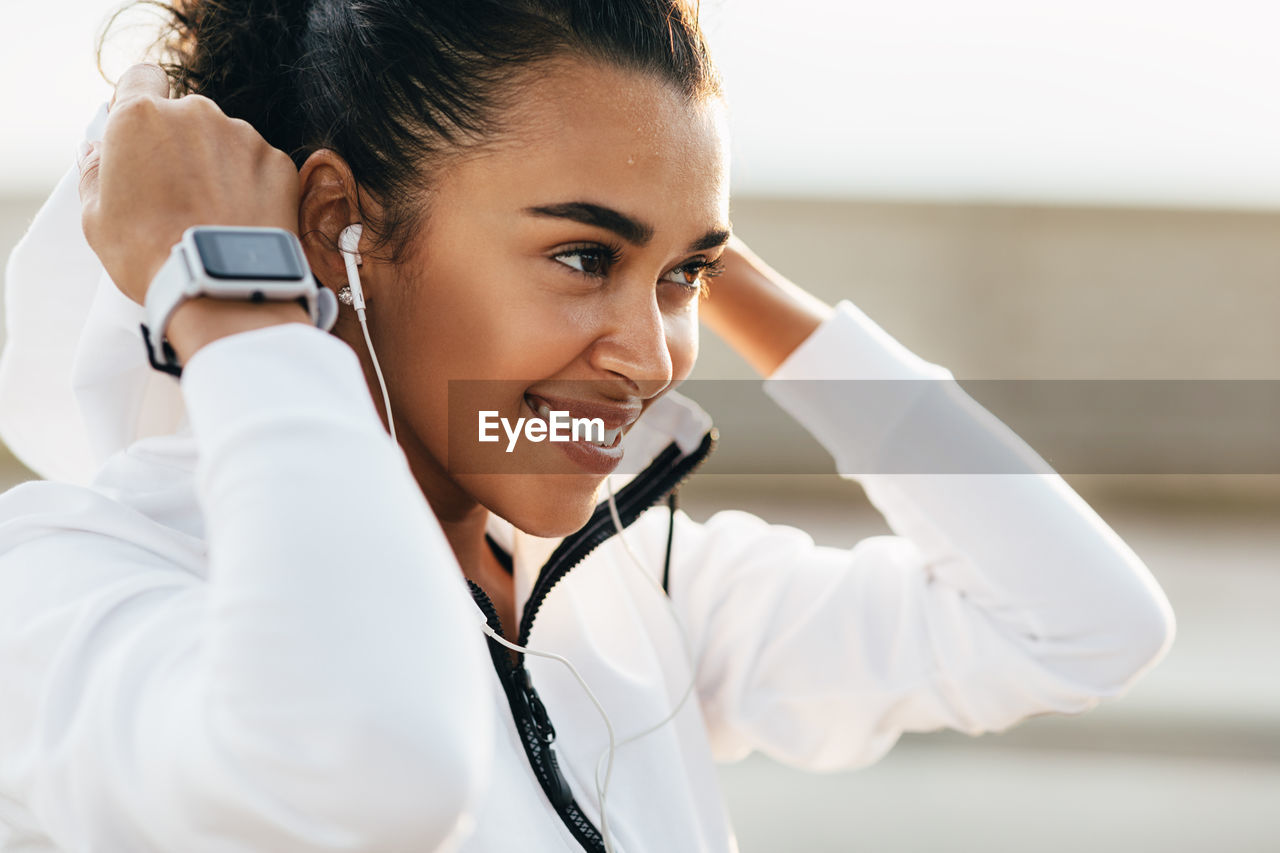 Close-up of smiling woman listening music