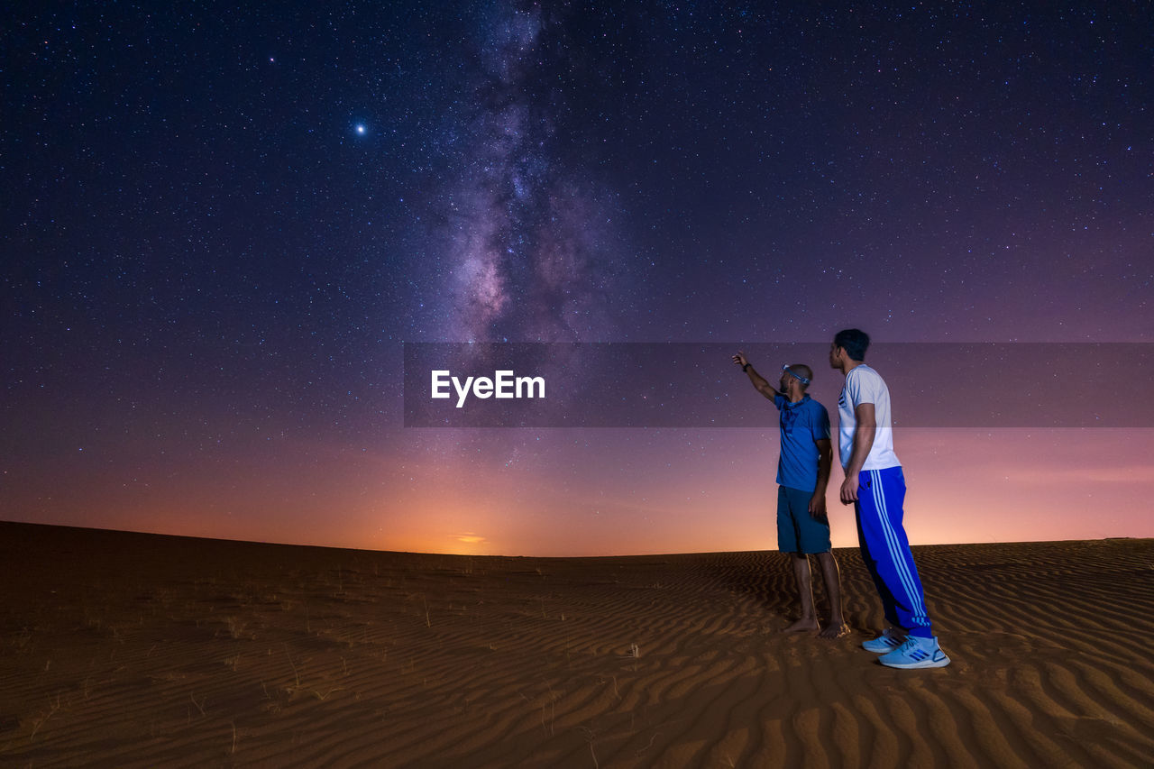 MAN AND WOMAN STANDING AGAINST CLEAR SKY