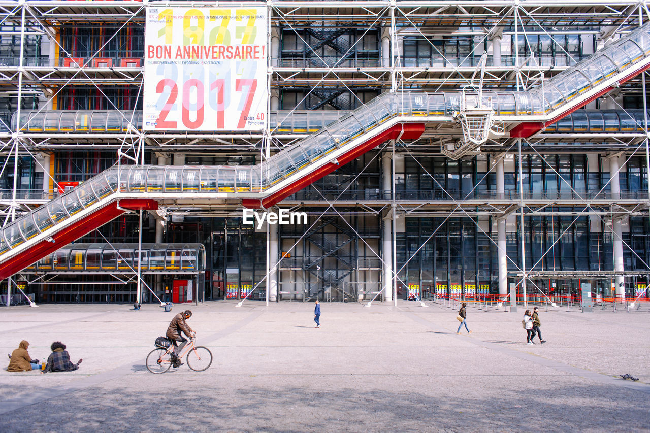 PEOPLE ON BICYCLE AGAINST BUILDINGS