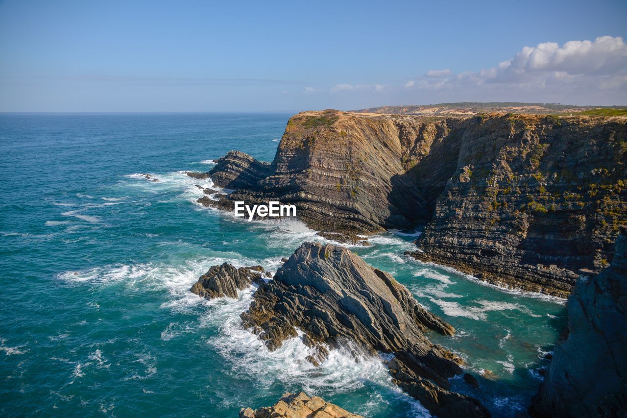 Scenic view of rocks in sea against sky