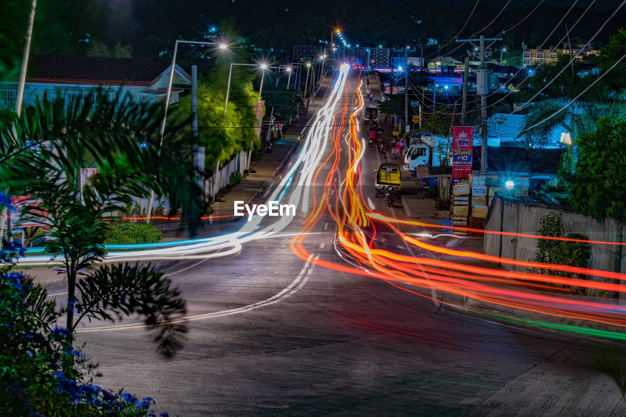 HIGH ANGLE VIEW OF LIGHT TRAILS ON ROAD AT NIGHT