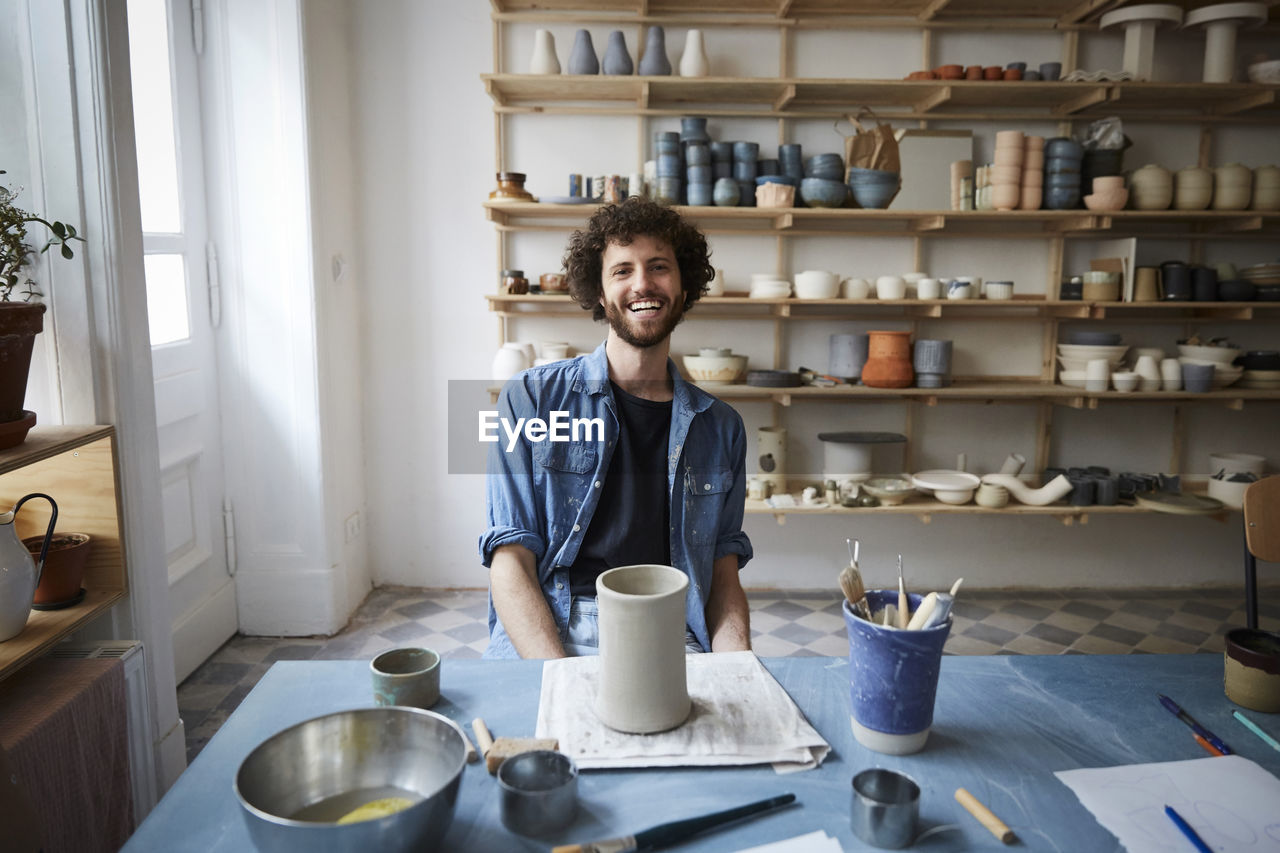 Portrait of smiling man sitting in pottery class