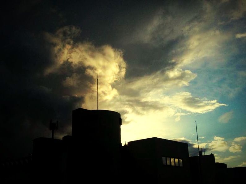 Silhouette buildings against cloudy sky