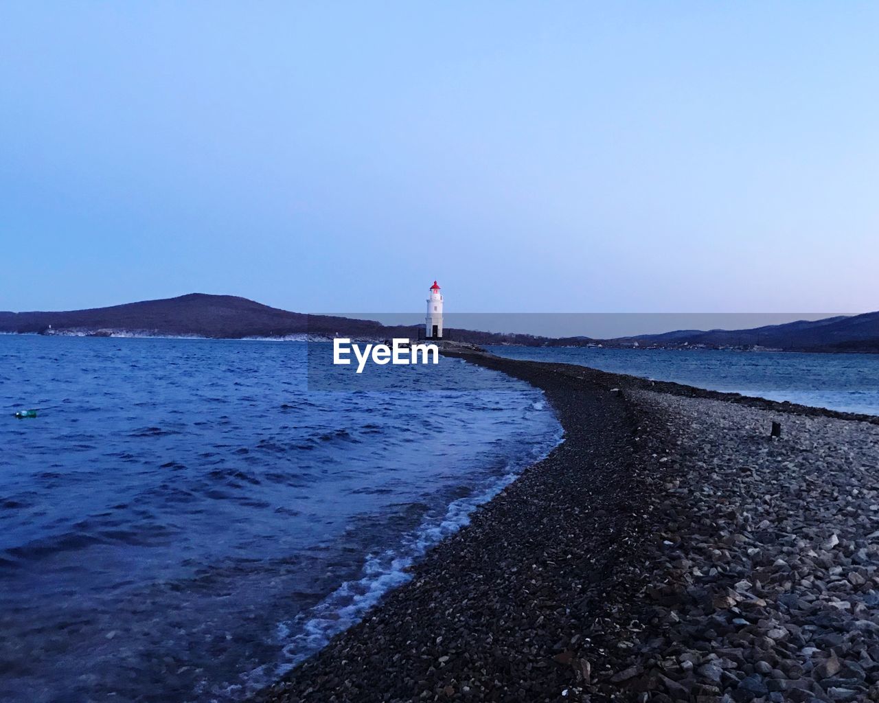 LIGHTHOUSE ON BEACH AGAINST CLEAR SKY