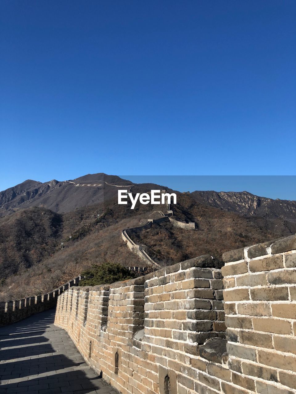 Steps leading towards mountains against clear blue sky