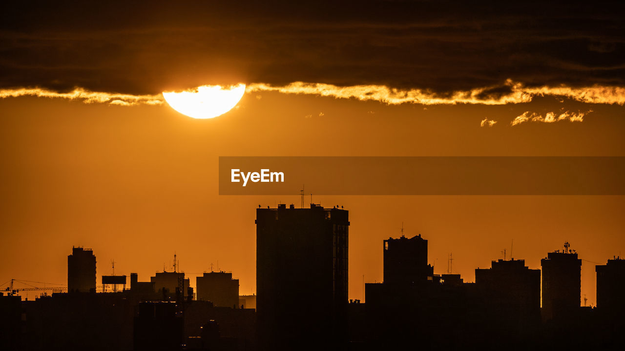 SILHOUETTE BUILDINGS AGAINST SKY AT SUNSET