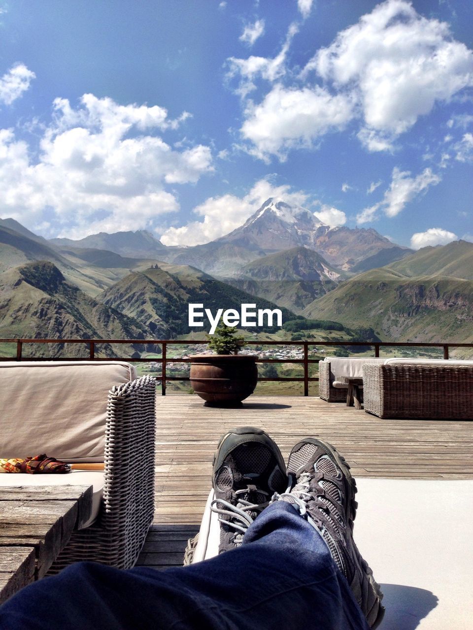 Low section of man relaxing at resort against majestic mountains