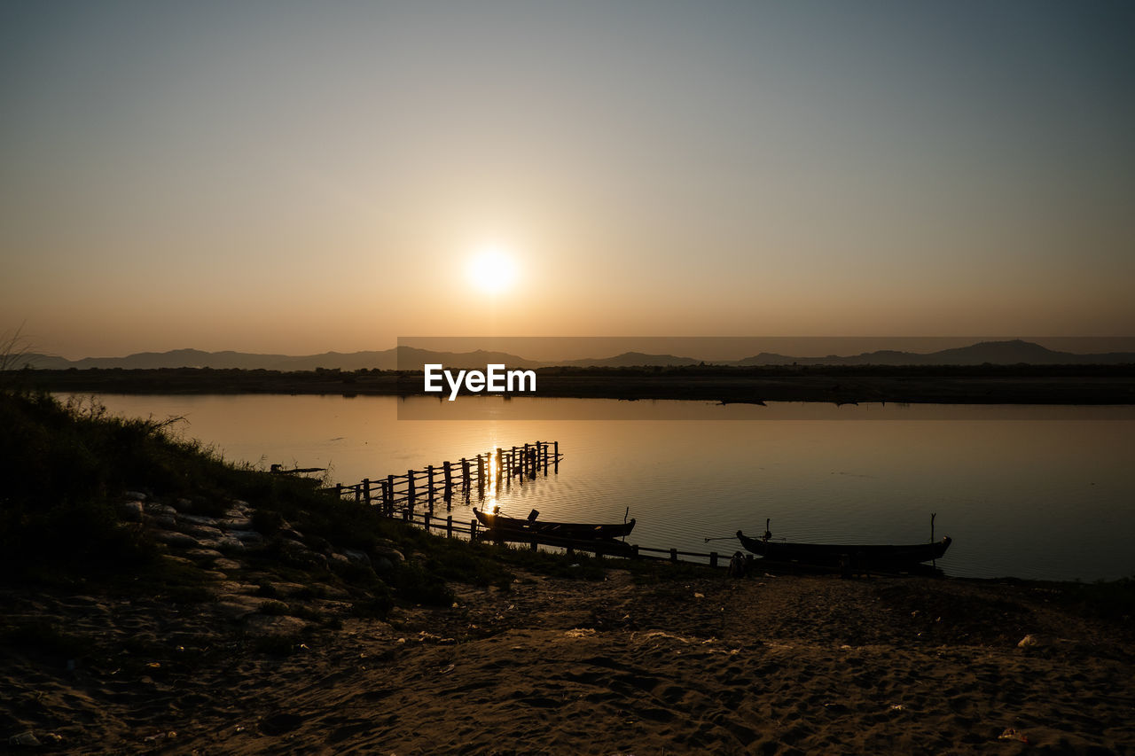 Scenic view of river in bagan against sky during sunset