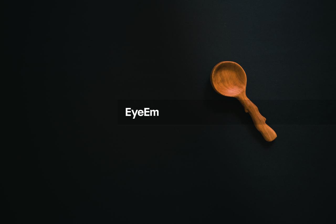 Close-up of wooden spoon against black background