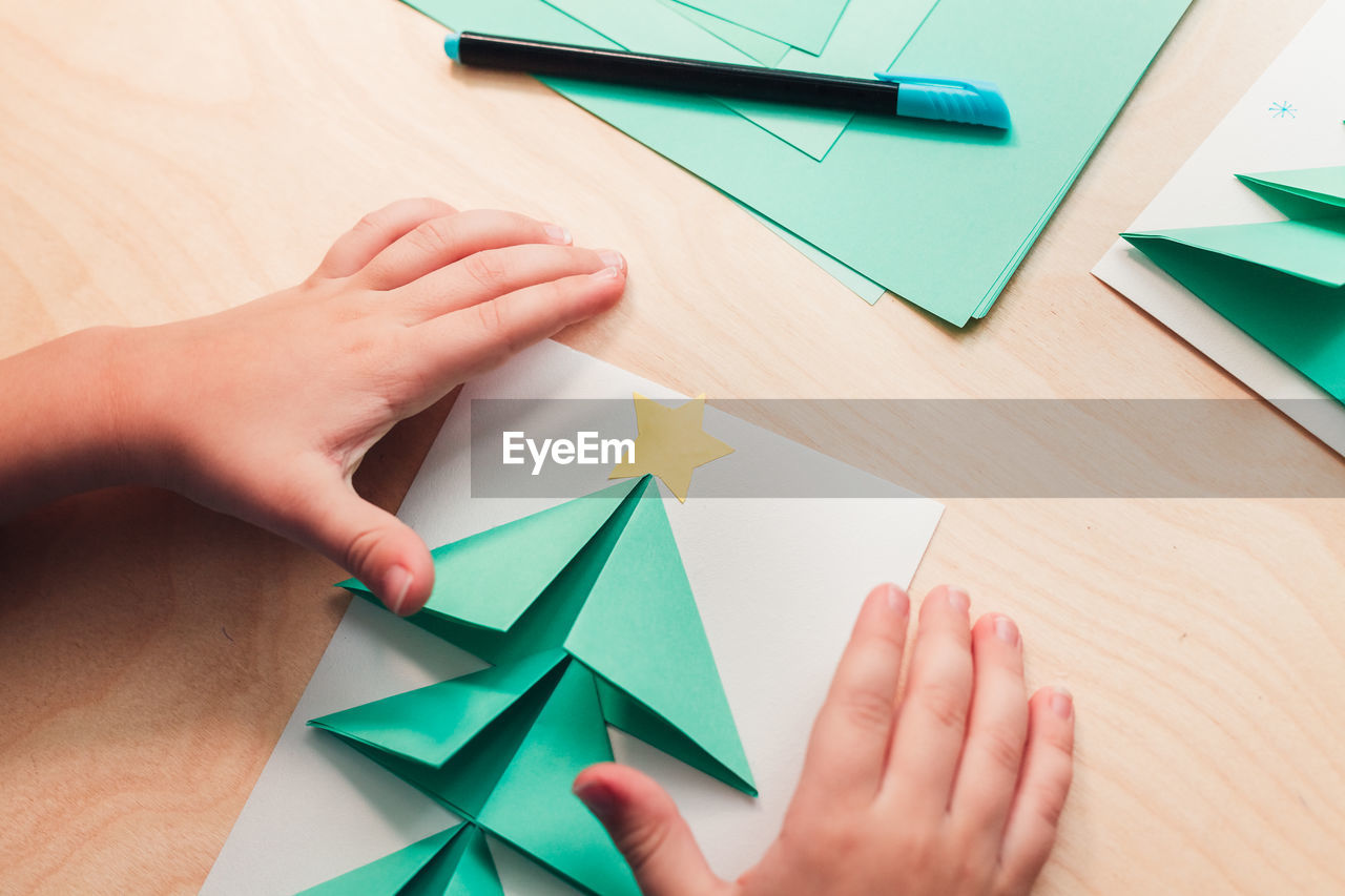 HIGH ANGLE VIEW OF HUMAN HAND HOLDING PAPER WITH TEXT