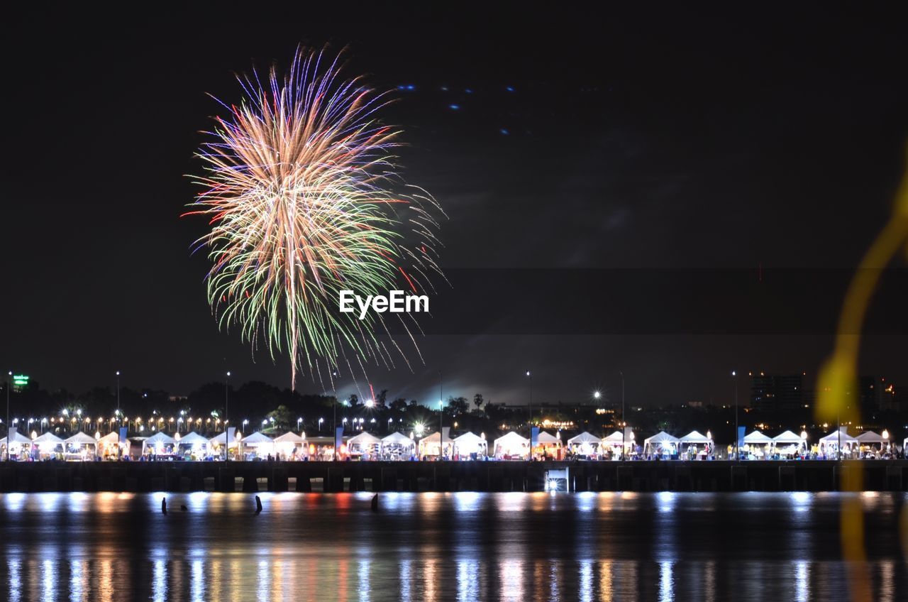 Firework display against sky at night