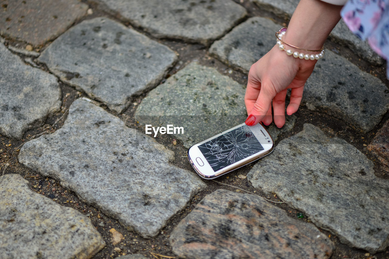 HIGH ANGLE VIEW OF MAN HOLDING SMART PHONE