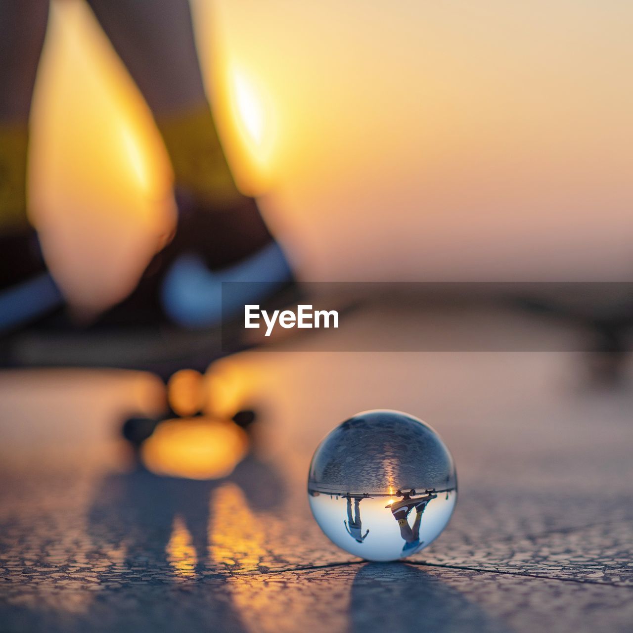 Close-up of illuminated ball on tiled floor against sky during sunset