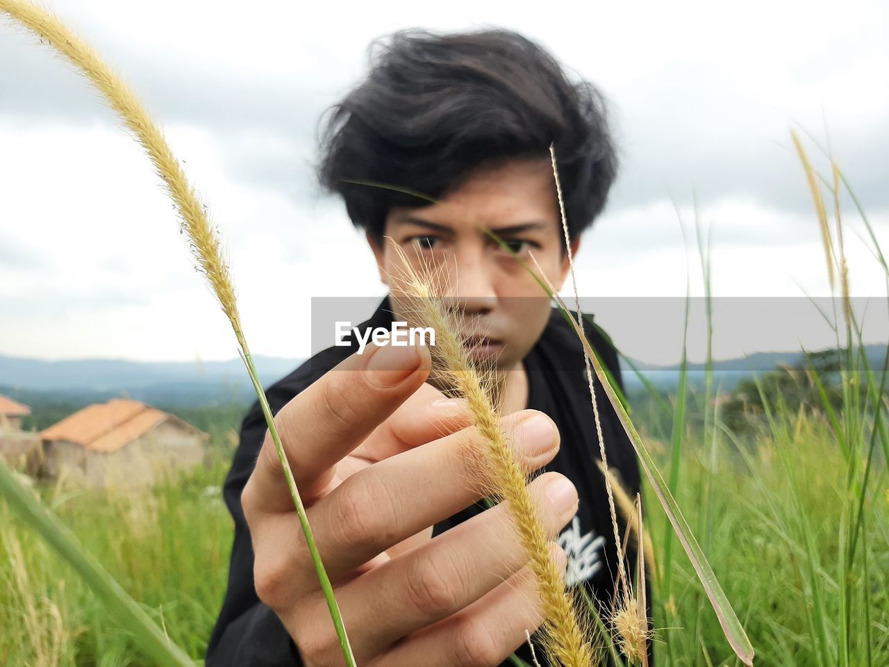 Portrait of young man looking away on field