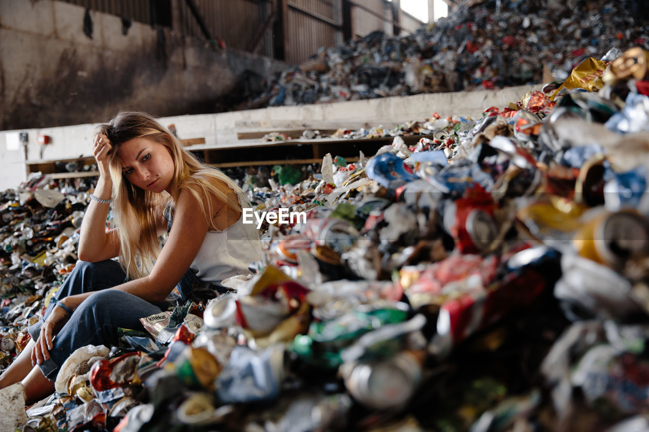 Young woman sitting on garbage