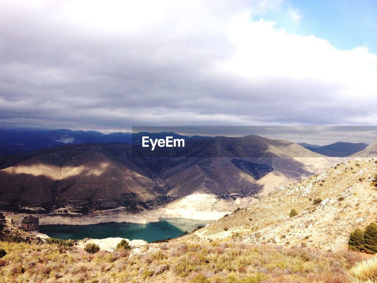 Scenic view of mountains against cloudy sky