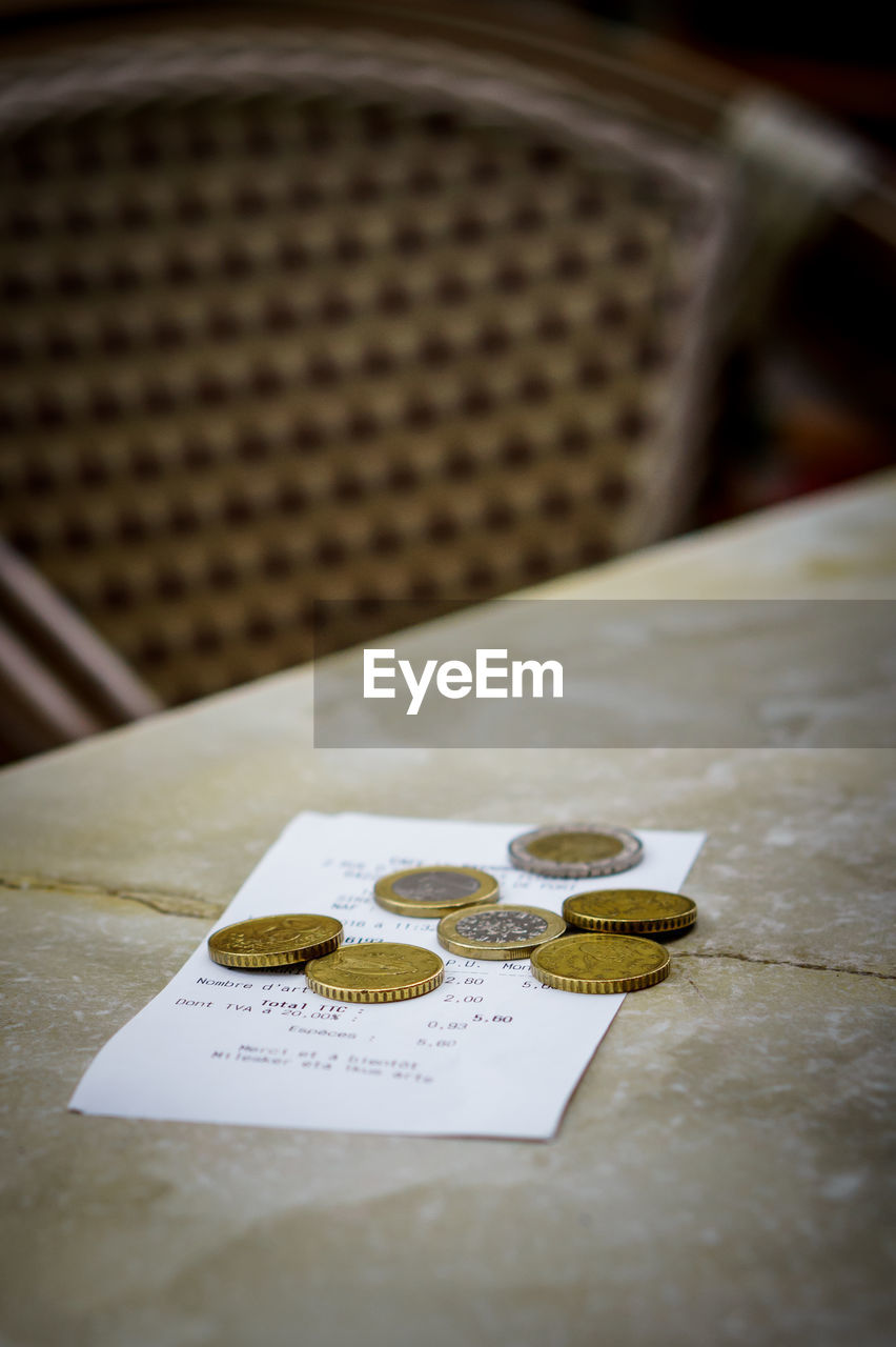 Close up of paper with coins on table