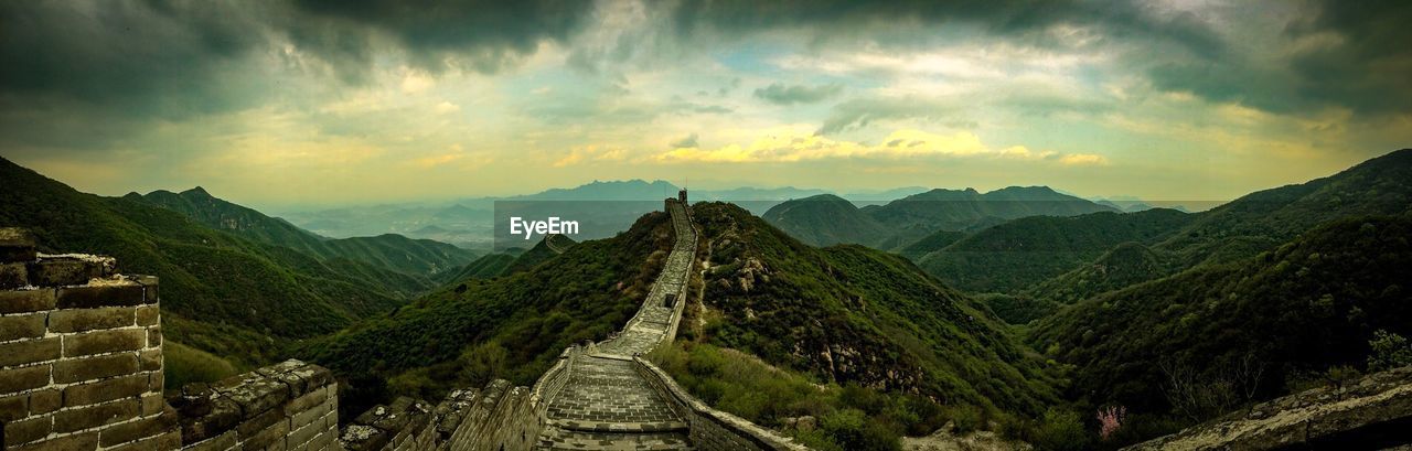 Scenic view of great wall of china and landscape against cloudy sky