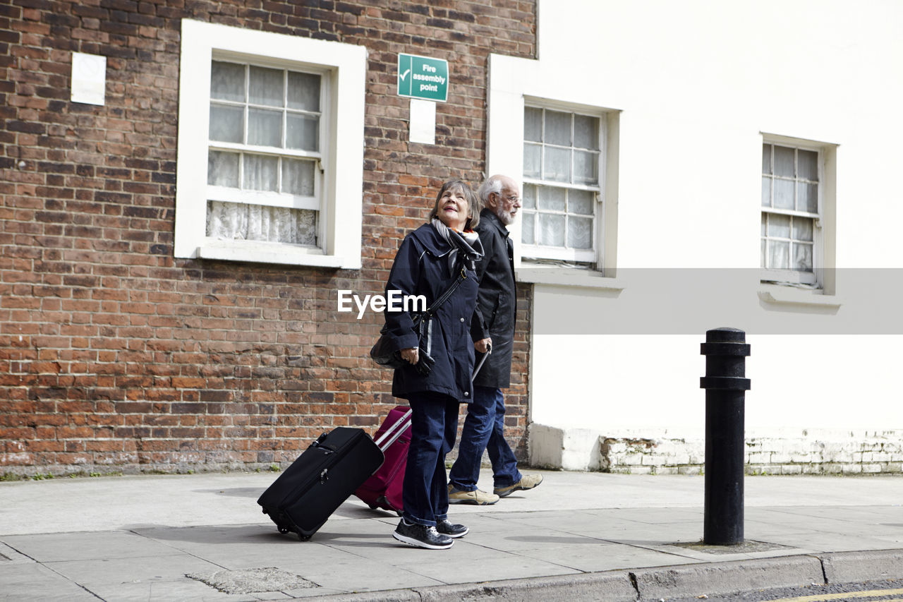 Senior couple walking with luggage