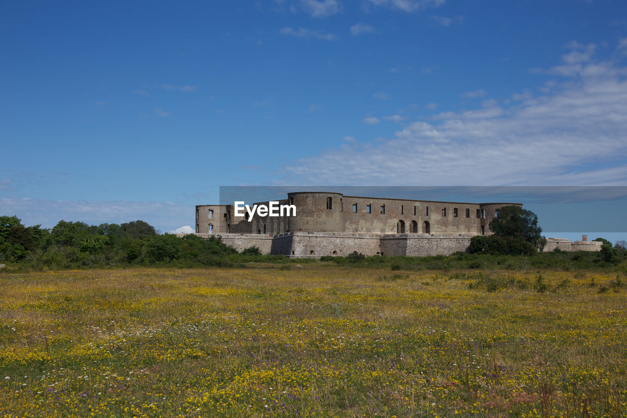 Built structure on field against sky