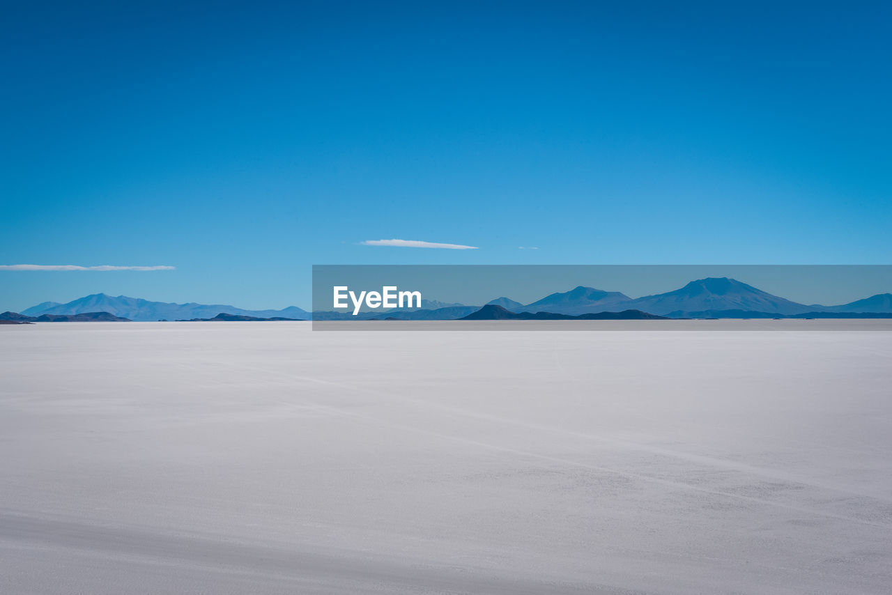 Scenic view of desert against clear blue sky