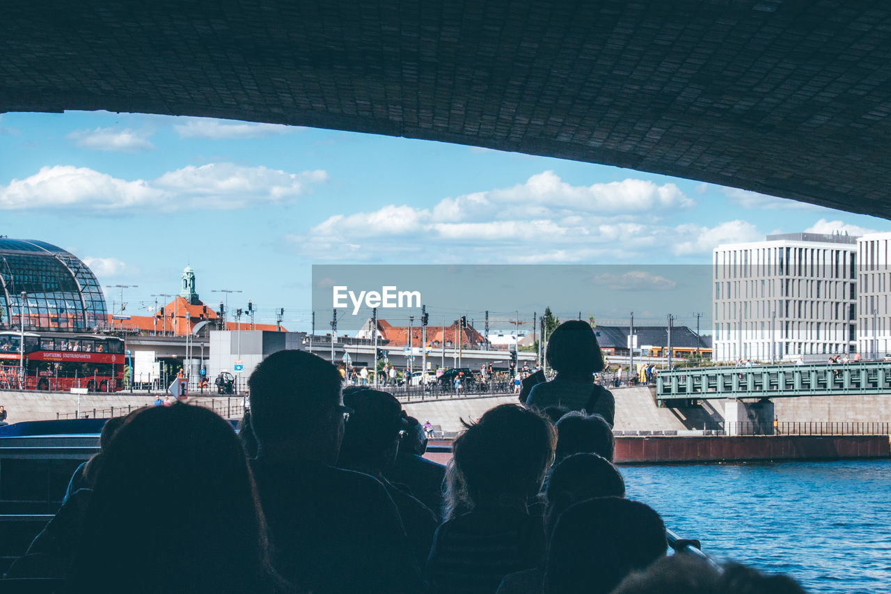 People on ferry boat below bridge in spree river