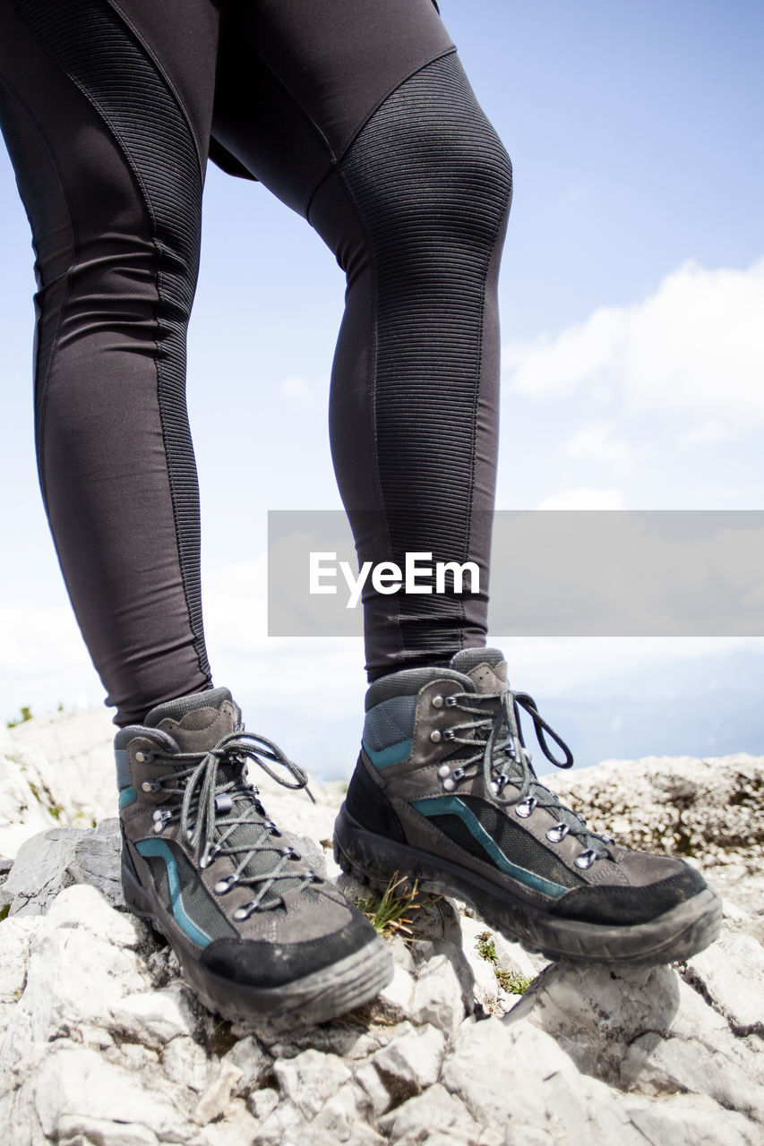 human leg, footwear, low section, adult, shoe, one person, limb, human limb, nature, sky, standing, day, women, cloud, clothing, leisure activity, rock, lifestyles, land, outdoors, trousers, sports, pants, blue, tights, young adult, sunlight