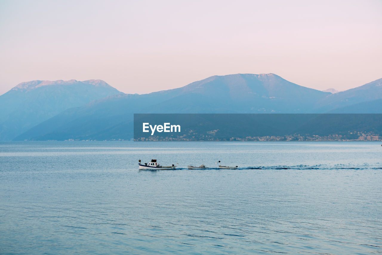 SCENIC VIEW OF SEA AGAINST MOUNTAIN