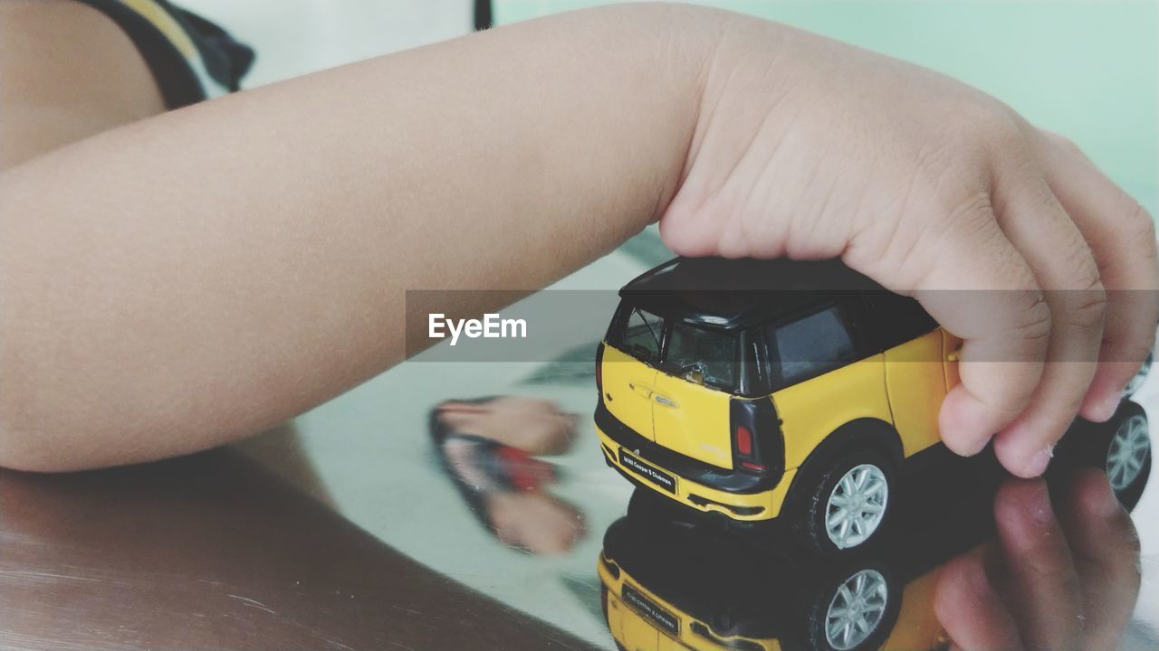 CLOSE-UP OF BOY WITH TOY CAR