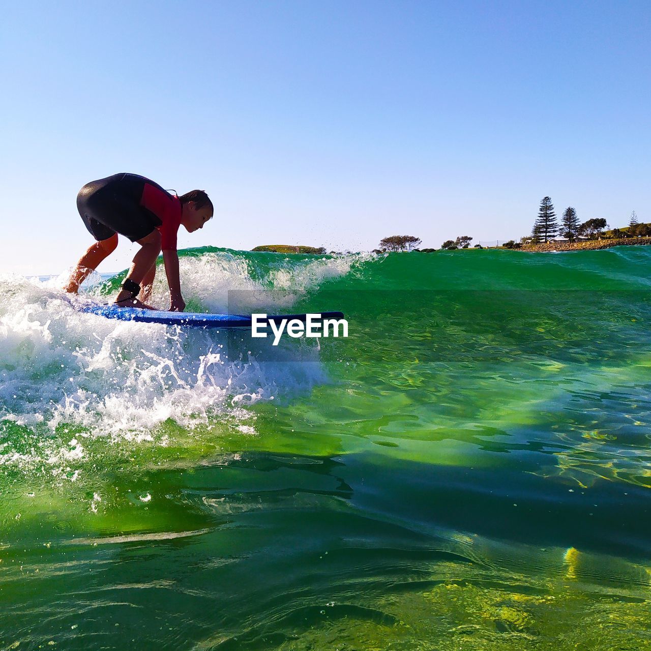 Full length of boy surfing in sea against sky