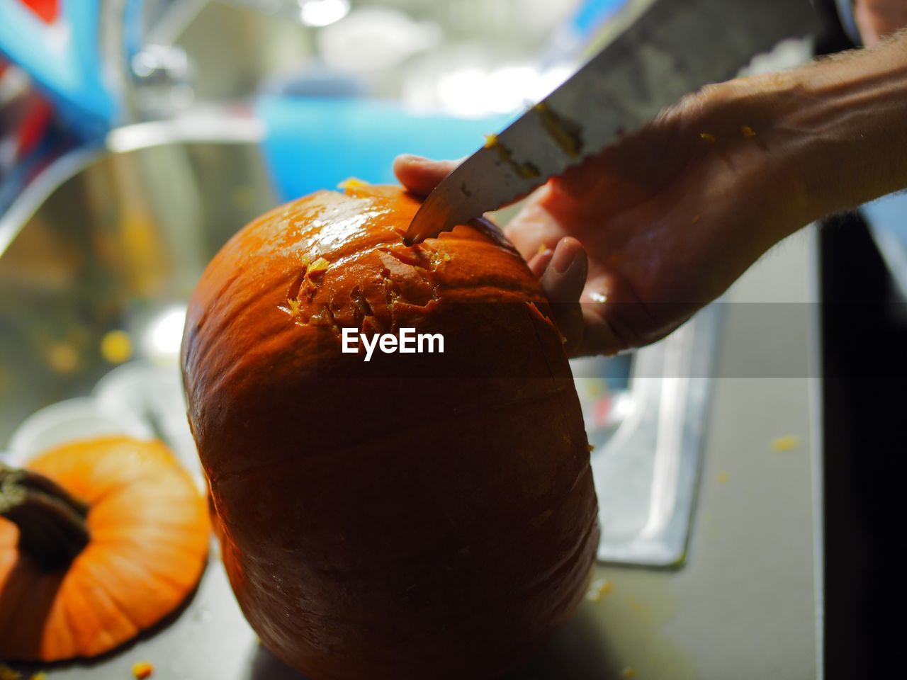 Close-up of hand carving a pumpkin