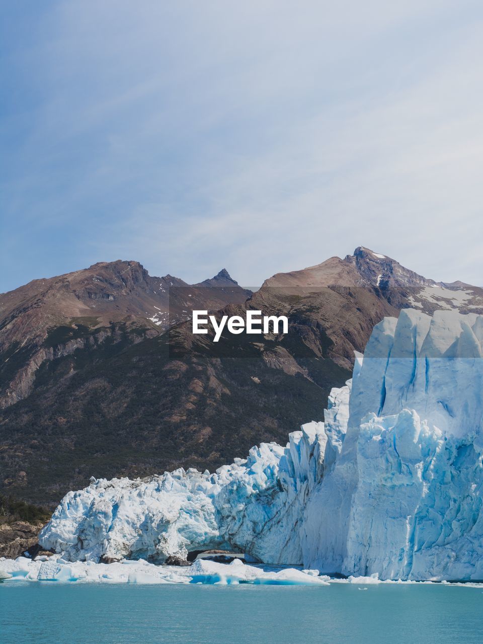 Scenic view of snowcapped mountains by sea against sky