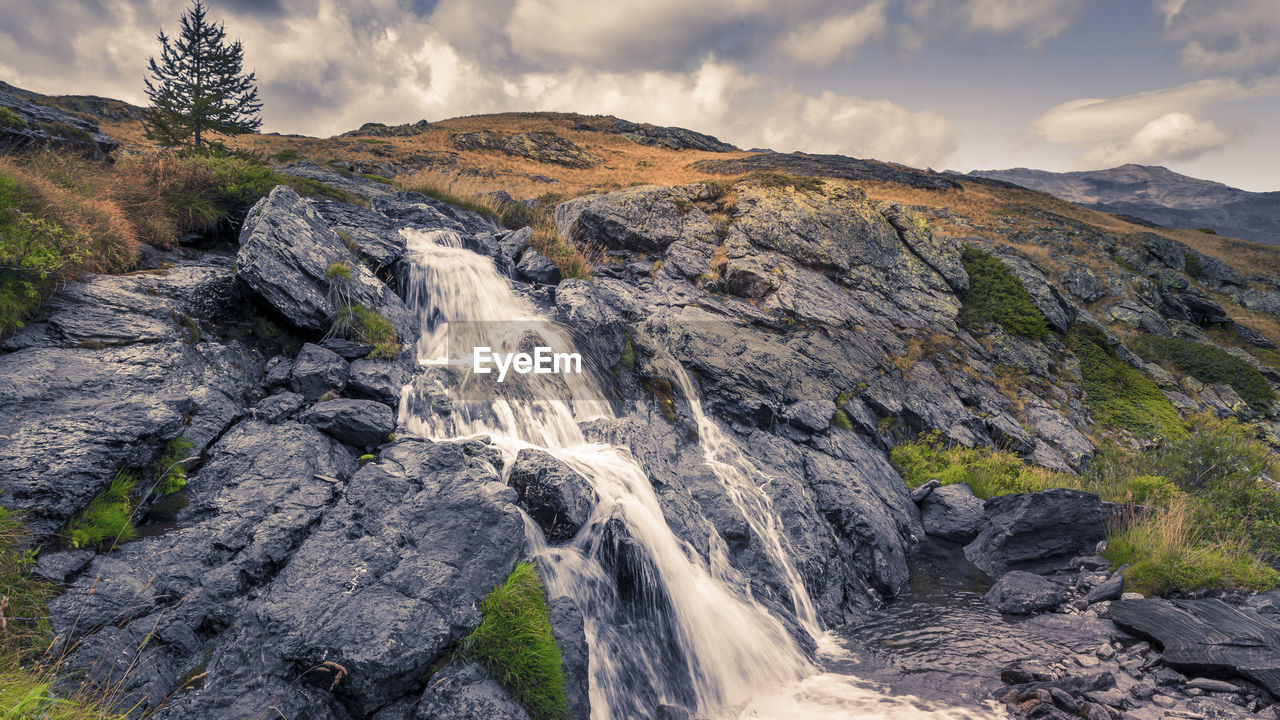 Scenic view of waterfall against sky