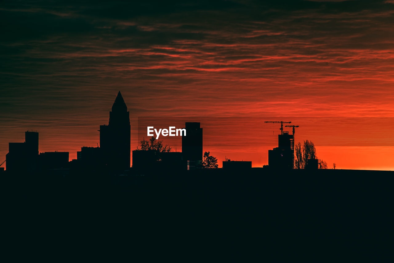 Silhouette of buildings in city during sunset