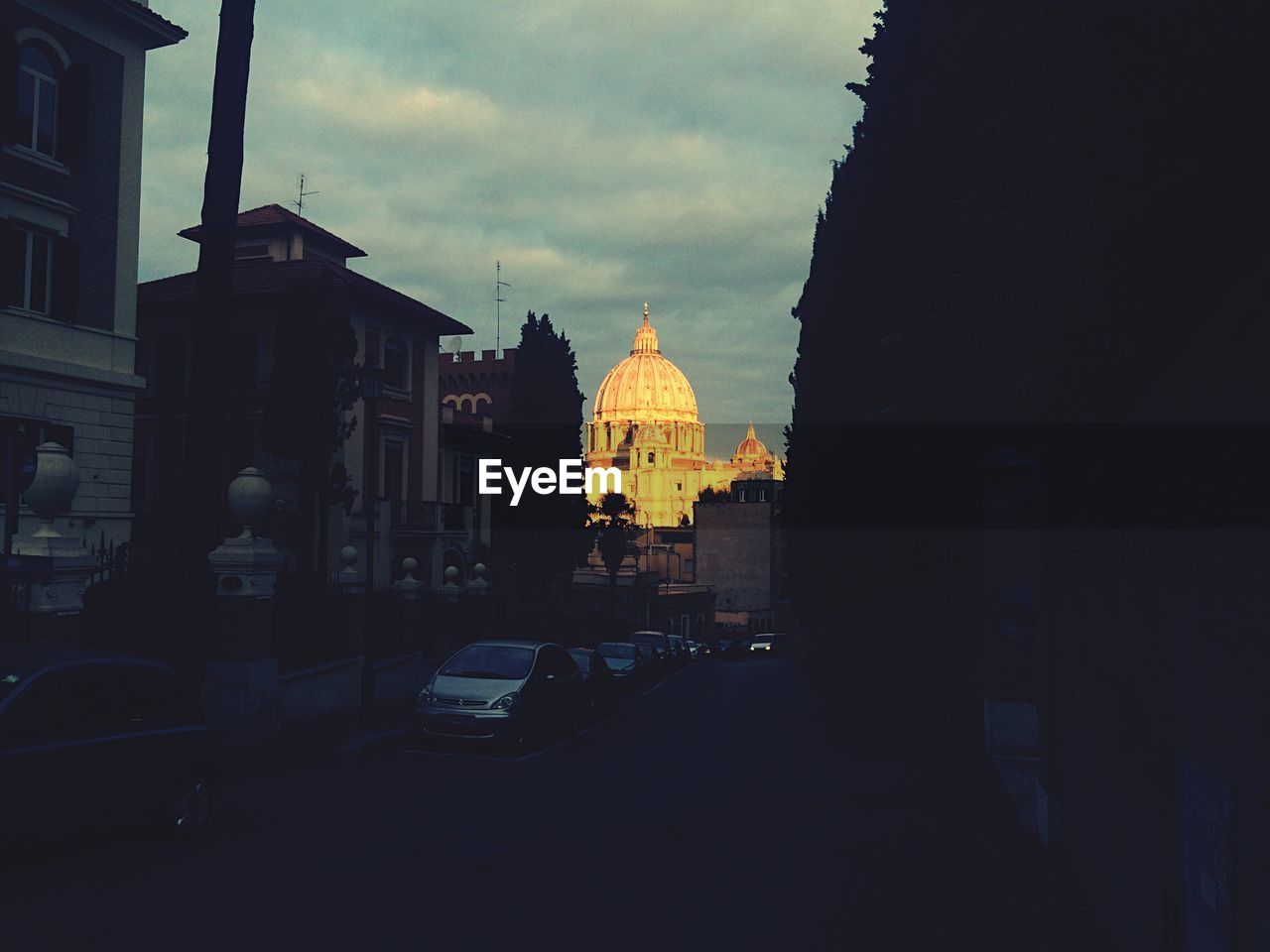 City street by old cathedral against sky at morning