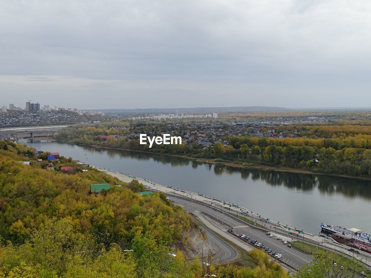 HIGH ANGLE VIEW OF RIVER AMIDST CITYSCAPE AGAINST SKY