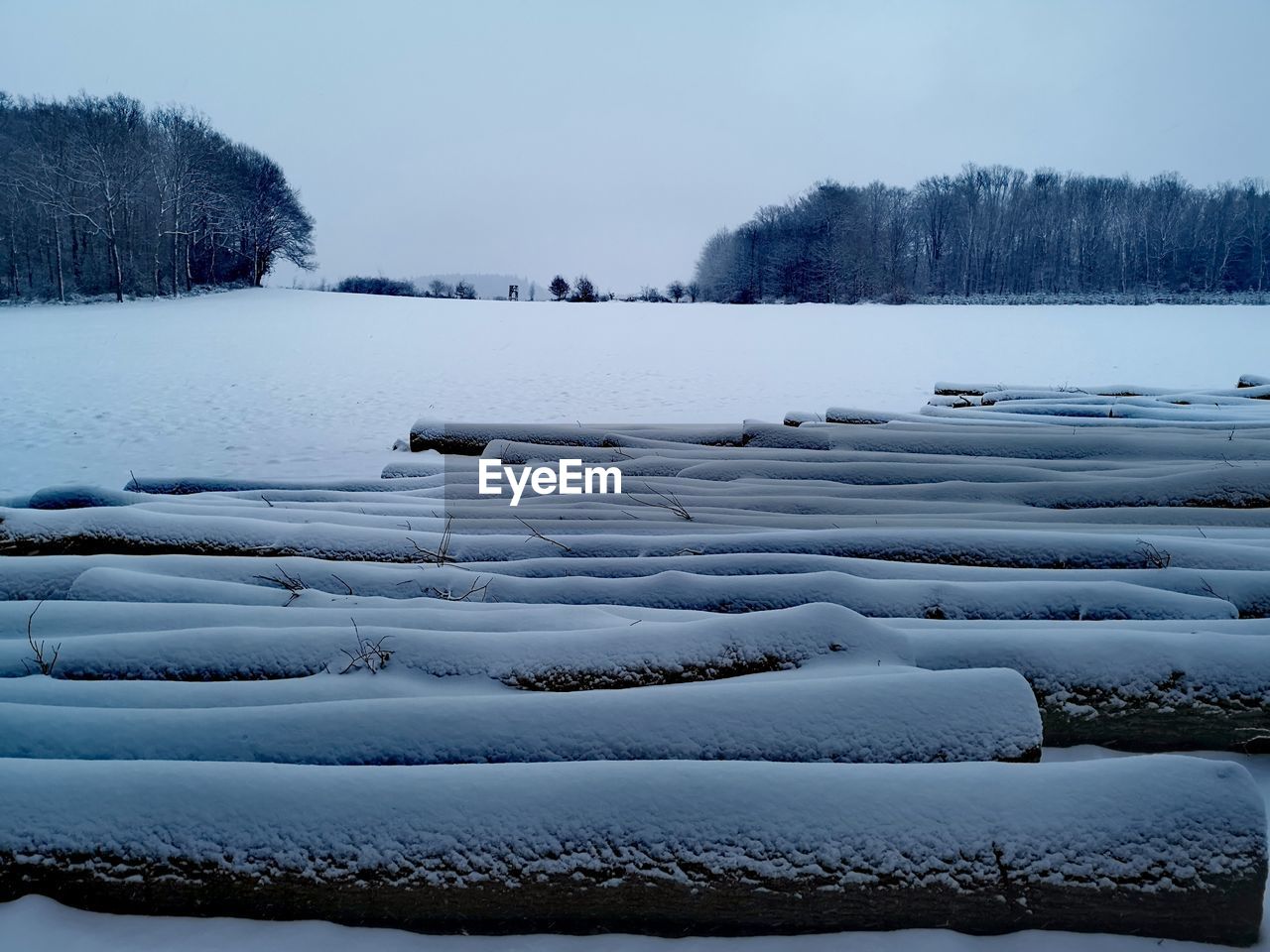 Scenic view of snow covered field against sky